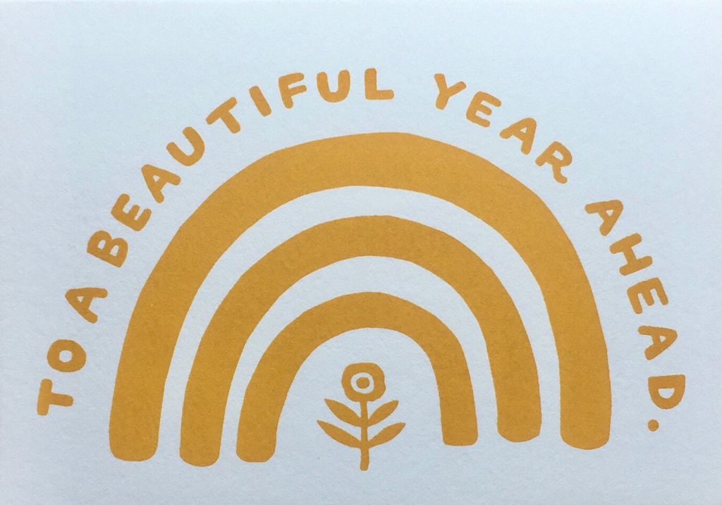 Greeting card with the words "To a beautiful year ahead." over 3 nesting arches and a flower. Printed in mustard yellow on white.